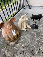 Three pig figurines grouped on balcony