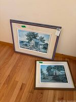 Both framed prints leaning against wall