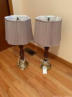 Both table lamps showing overall design, wood columns, brass-tone bases, pleated shades