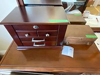 Front view of dark wood jewelry chest next to light wood box