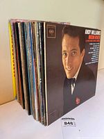 Front view showing stack with Andy Williams LP leading, approx. 20 records visible