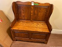 Front view of wooden storage bench with paneled back and front