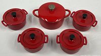All five red enameled cast iron pieces with lids in view