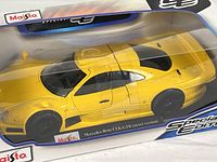 Front three-quarter view of boxed yellow Mercedes-Benz CLK-GTR model
