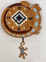 Full view of circular wall clock with wrap-around lizard and hanging pendulum