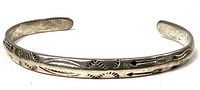 Top view of sterling silver cuff showing stamped arrow and geometric designs