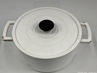 Top view of white enameled Dutch oven with lid and handles