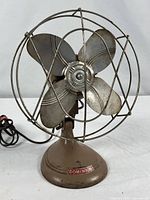 Front view showing complete fan with wire cage and four metal blades