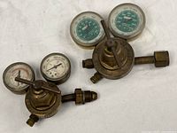 Both brass Victor regulators with dual gauges visible