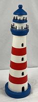 Full view of striped wooden lighthouse showing overall design and colors