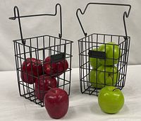 Both wire baskets with red and green faux apples displayed