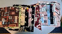 Stack of assorted mid-century atomic fabric samples showing variety of prints and colours