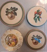 Four decorated round tins displayed top view