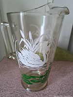 Side view of glass pitcher showing swan design and handle