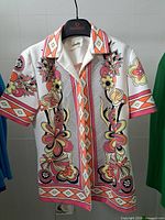 Front view of blouse on hanger showing print, collar and sleeves