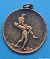 Bronze-tone medal depicting two wrestlers