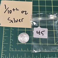 Full view of silver round beside note showing weight