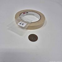Coin next to masking tape roll for scale