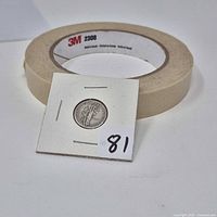 Coin in 2x2 flip next to masking tape roll