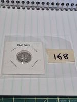 Coin in labelled flip next to lot tag