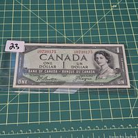 Obverse of 1954 $1 banknote in sleeve showing serial number and portrait