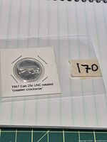 Coin in cardboard flip beside lot number tag