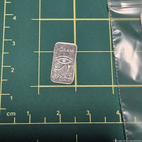 Front of rectangular silver bar showing Eye of Horus design and purity stamp