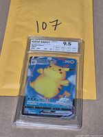 Encapsulated Surfing Pikachu VMAX card in slab on envelope