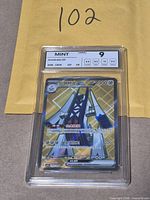 Front of encapsulated Archaludon ex card showing NXR Mint 9 label and gold secret rare artwork