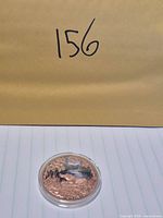 Obverse view showing alligator scene within capsule