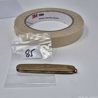 Knife closed beside masking tape for scale