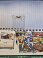 Stack of assorted Pokémon cards plus visible loose cards