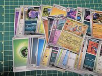 Spread of mixed English and Korean Pokémon cards on cutting mat
