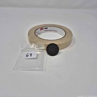 Front of Montreal UN SOU token beside tape roll for scale