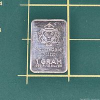 Front view of Scottsdale Mint 1 g silver bar on measuring mat