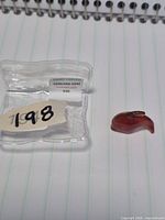 pendant beside clear box showing label inside