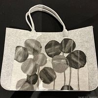 Front view of grey felt tote bag with abstract leaf design