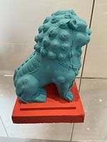 Right side view of turquoise lion on red base