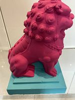 Left rear side view of magenta lion maquette on teal base