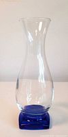 Front view of clear glass vase on cobalt blue base