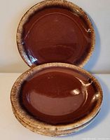 Stack and two displayed Hull Brown Drip dinner plates showing glaze and rim