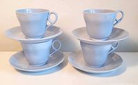Four pastel blue Grindley Lupin Petal cups stacked on matching saucers