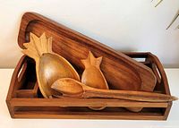 Full view of all five monkeypod wood serving pieces nested in tray