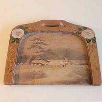Full view of wooden crumb tray showing handle, painted landscape and floral border