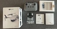 Overall lot showing drone, remote, box, accessories and paperwork