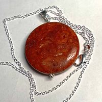 Round red coral pendant on sterling chain close-up
