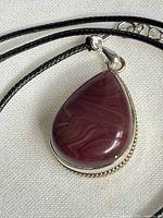 Front view of teardrop amethyst pendant on cord