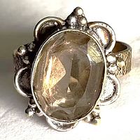 Front view showing oval faceted smoky quartz and ornate silver bezel