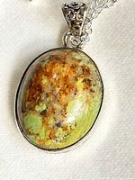 Close-up of pendant showing stone, bezel and bail