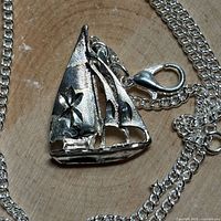 Close-up of sailboat pendant and clasp on chain